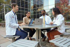 A group of IU medical students sits around a table.